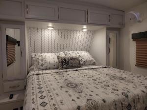 1 dormitorio con cama con edredón y almohadas en The Torres' Camper Experience!, en Tampa 9 fotos más