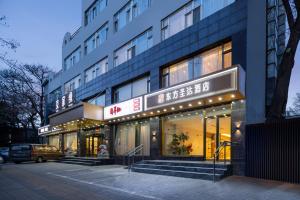 un edificio con letreros en el costado en East Sacred Hotel - It is very close to the Yonghegong temple And Very close to the bird's nest water cube, en Beijing