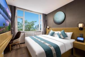 a hotel room with a bed and a large window at Oriental Sundar Hotel near China-Japan Friendship Hospital-Bird's Nest and Water Cube-Yonghe Palace-Nanluoguxu Alley in Beijing