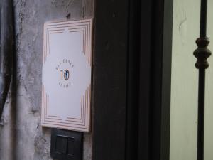 a white sign on the side of a wall at Residence El Diez in Naples