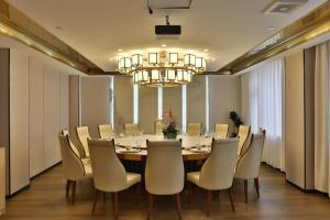 a dining room with a long table and chairs at Oriental Sundar Hotel near China-Japan Friendship Hospital-Bird's Nest and Water Cube-Yonghe Palace-Nanluoguxu Alley in Beijing