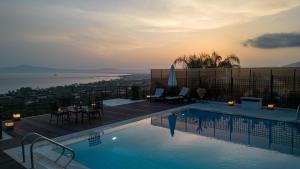ein Schwimmbecken mit Blick auf das Wasser in der Unterkunft Senso Panorama Luxury Villa in Kalamata