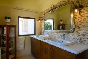 ein Badezimmer mit Waschbecken und großem Spiegel in der Unterkunft Senso Panorama Luxury Villa in Kalamata