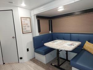 a dining room with a table and a blue bench at The Torres' Camper Experience! in Tampa