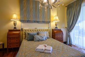 ein Schlafzimmer mit einem Bett mit zwei Handtüchern und zwei Lampen in der Unterkunft Senso Panorama Luxury Villa in Kalamata