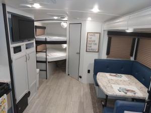a small room with two bunk beds and a table at The Torres' Camper Experience! in Tampa
