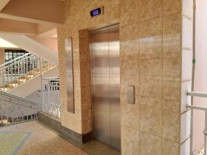 EmbuComfort Haven with Secure Parking & Unlimited WiFi的楼梯所在的建筑中的电梯
