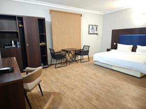 a hotel room with a bed and a table and chairs at Safa PARK HOTEL YANBU فندق صفا بارك ينبع in Yanbu