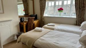 Un pat sau paturi într-o cameră la The Cricketers Inn
