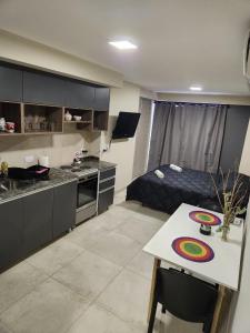 a room with a kitchen and a bed and a table at Casita de Tucumán - Santiago in San Miguel de Tucumán