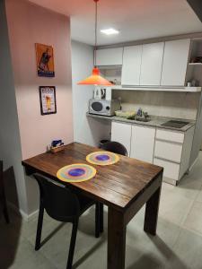 a kitchen with a wooden table with two plates on it at Casita de Tucuman - Blue in San Miguel de Tucumán