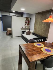 a living room with a table and a bed at Casita de Tucuman - Blue in San Miguel de Tucumán