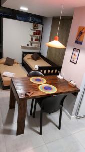 a room with a wooden table and two beds at Casita de Tucuman - Blue in San Miguel de Tucumán