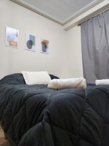 uma cama num quarto com um cobertor preto em Casita de Tucumán Apart - Cochera Cercana em San Miguel de Tucumán