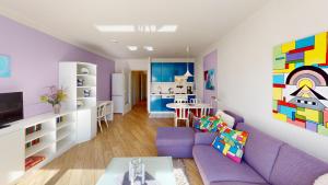 ペルツァーハケンにあるNeuKlosterhof App. 18の紫色のソファ付きのリビングルーム、キッチンが備わります。