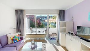 a living room with a couch and a tv at NeuKlosterhof App. 18 in Pelzerhaken
