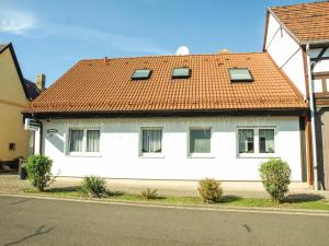 a white house with a red roof on a street at Pension-Rappteller in Apfelstädt