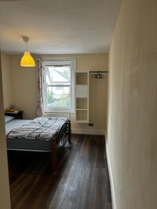 a small bedroom with a bed and a window at Nice and Pleasant in Thornton Heath