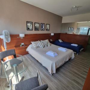 a bedroom with a bed and a glass table and chairs at Dg Apart Obelisco in Buenos Aires