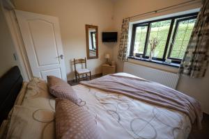 um quarto com uma cama e uma janela em The New Larches em Bewdley