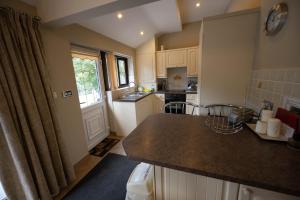 een keuken met witte kasten en een aanrecht bij The New Larches in Bewdley