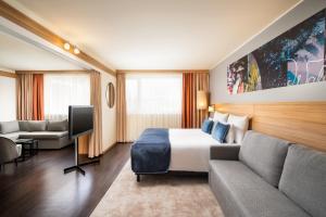 ein Hotelzimmer mit einem Bett und einem Sofa in der Unterkunft Leonardo Hotel Vienna Schönbrunn in Wien