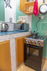 a kitchen with a stove and a microwave at modern home 2 wifi acacia mall in Kampala