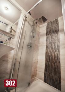 La salle de bains est pourvue d'une douche avec une porte en verre. dans l'établissement Shut Eyes, à Londres