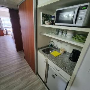 a small kitchen with a sink and a microwave at Dg Apart Obelisco in Buenos Aires