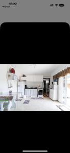 a large kitchen with white cabinets and a table at House the Dream in Curitiba