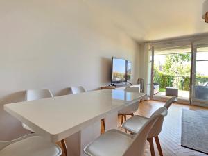 a meeting room with a white table and chairs at Grand 3 pièces, 2 jardins, Parking sous sol. in Deauville