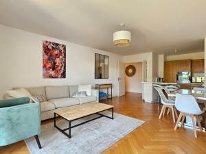 a living room with a couch and a table at Grand 3 pièces, 2 jardins, Parking sous sol. in Deauville