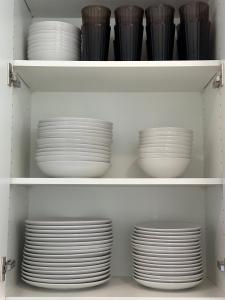 a shelf filled with white plates and bowls at The Evergreen House in Red Deer