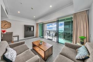 a living room with two couches and a table at Stunning Auckland Harbour Views in Auckland