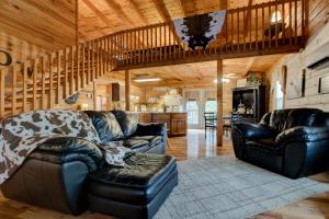 a living room with leather couches and a kitchen at The Willow, Secluded and Cozy country cabin in Ravenna