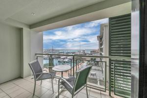 uma varanda com mesa e cadeiras e vista para o oceano em Stunning Auckland Harbour Views em Auckland