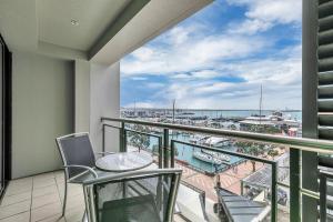 a balcony with chairs and a view of a harbor at Stunning Auckland Harbour Views in Auckland