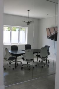 Sala de conferencias con sillas, mesa y pared de cristal en Digital Nomad's Nest, en Ciudad del Cabo