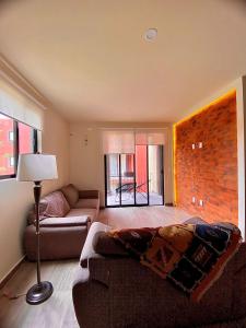 a living room with a couch and a brick wall at TriBeCa San Miguel in San Miguel de Allende
