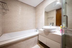 a bathroom with a sink and a bath tub and a sink at LANDMARK PLUS RESIDENCES LUXURY SUITE in Ho Chi Minh City