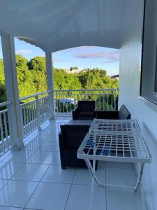 - une terrasse couverte avec un canapé et une table sur un balcon dans l'établissement Maison dans les hauteurs, au Gosier