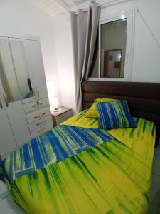 1 dormitorio con cama, tocador y espejo en Maison dans les hauteurs, en Le Gosier