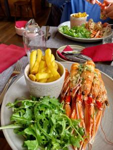 um prato de comida com camarão e batatas fritas numa mesa em Appartement Studio 35 m2 face à l'Ocean em Saint-Brévin-les-Pins