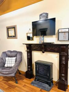 uma sala de estar com uma lareira, uma cadeira e uma televisão em Acorn Hideaways Canton Secluded Sherlock Holmes Suite King Bed em Canton