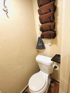 a bathroom with a toilet and a pile of towels at Acorn Hideaways Canton Secluded Sherlock Holmes Suite King Bed in Canton