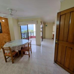- une salle à manger avec une table, des chaises et une porte dans l'établissement Apartamento en Santa Marta- Rodadero Laureles 6 by reservastodo, à Santa Marta