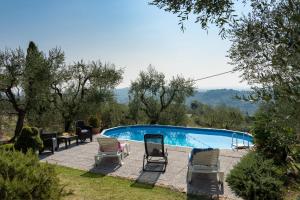 una piscina con dos sillas y una mesa en Casa Mony, en Capannori