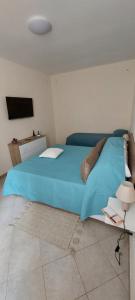 a large blue bed in a room with a tv at Casa Nanuzza in Naples