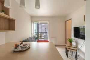 eine Küche und ein Wohnzimmer mit einem Holztisch in der Unterkunft Port Royal T2 Cosy parking Centre Plage in Le Grau-du-Roi