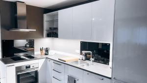 a kitchen with white cabinets and a sink at Ferienwohnung BERGSEERUHE - Allgäu - Wandern - Relaxen in Sulzberg